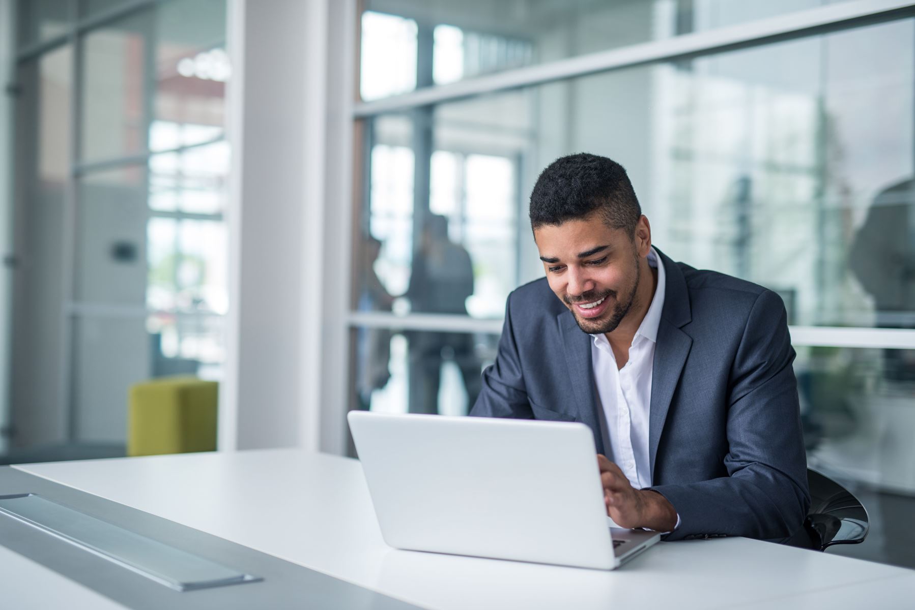 Man smiling while working on a laptop computer